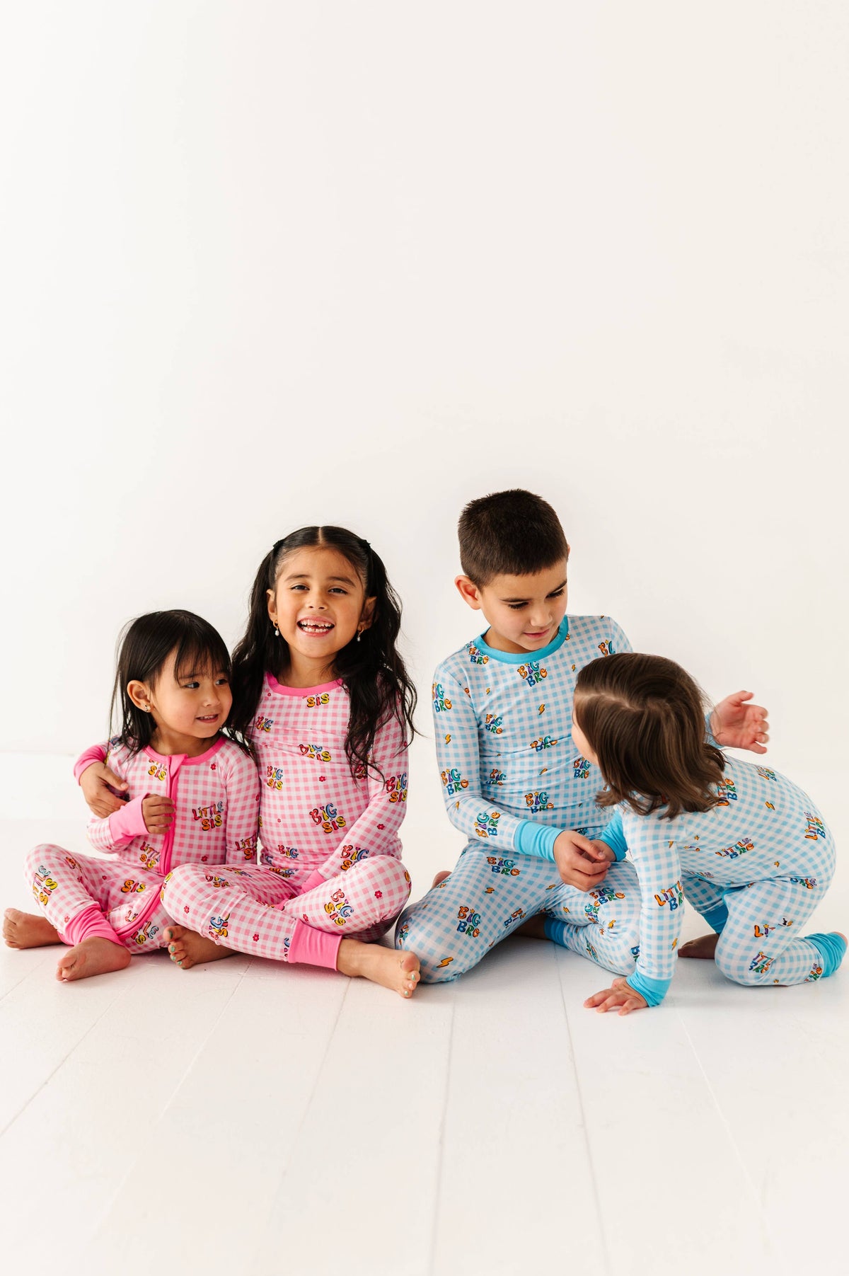 Four children wearing matching pajamas on a white background