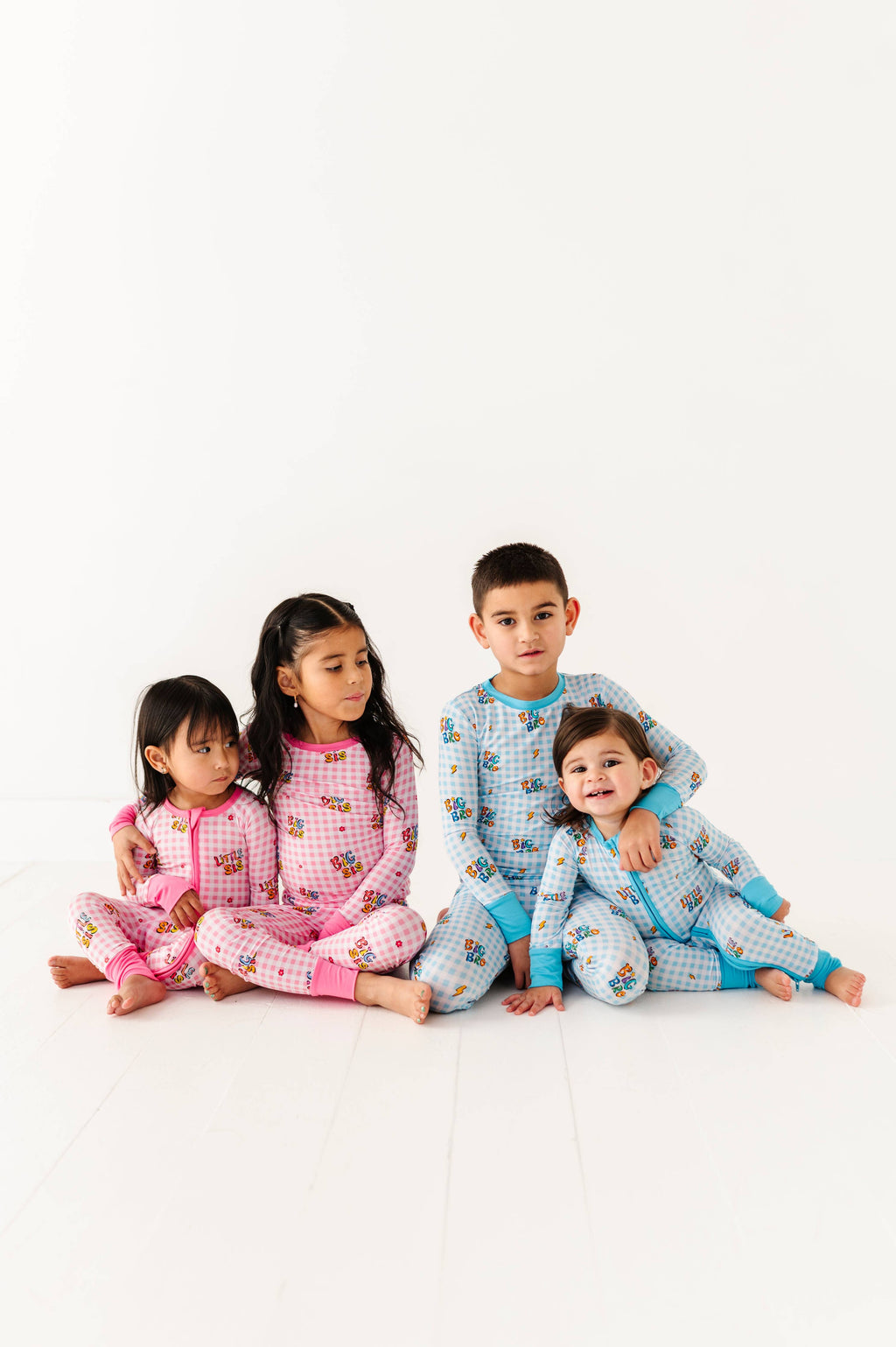 Four children wearing matching pajamas on a white background