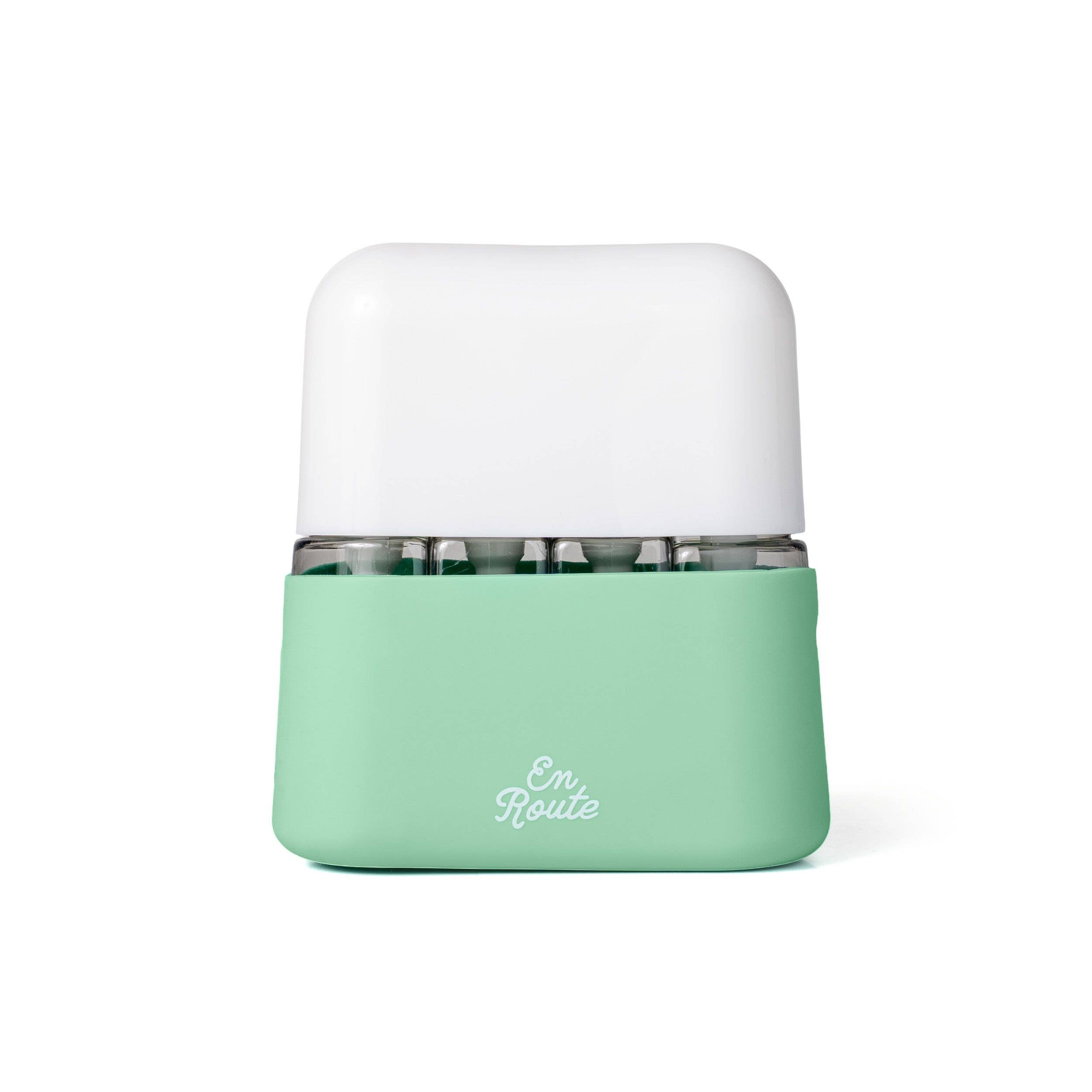 Compact mint green and white travel case holding the En Route - Bon Voyage 4 Piece Travel Bottles, designed for stylish and practical mom life essentials.
