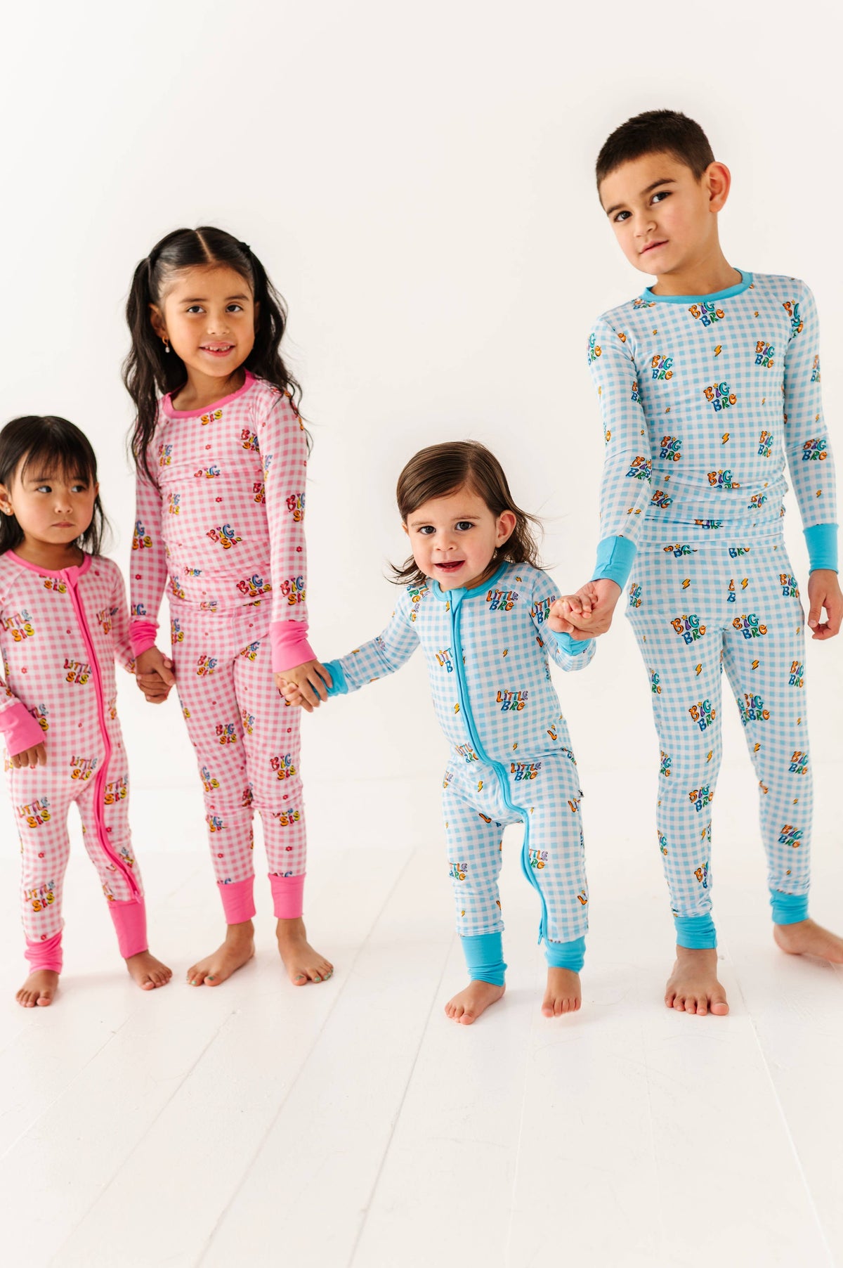 Four children wearing colorful pajamas on a white background