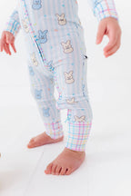 Baby wearing Kiki + Lulu - Peeps + Sleeps Convertible Footies featuring soft pastel colors with playful bunny and star prints, designed for comfort and style in a curated children’s boutique.