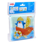 Penguin Bath Book with Squeaker featuring a colorful penguin illustration in a boat, designed for sensory play and early learning in the bath, ideal for children’s boutique collections.