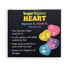 A square product box for 'Sugar Squeeze Heart' fidget toys on a white background. The box is black with colorful text and shows four heart-shaped fidgets in pink, yellow, purple, and blue with glitter.