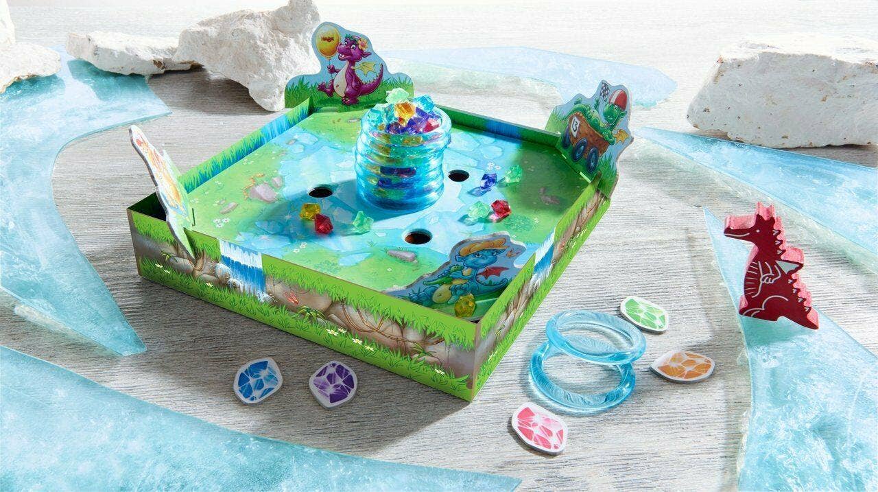 Dragon's Breath Game tabletop setup with colorful dragon-themed pieces, rings, and tokens on a green board, designed for imaginative play and educational fun.