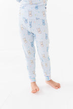 Child wearing light blue Kiki + Lulu - Peeps + Sleeps Kids Pajamas featuring playful bunny patterns and soft pastel stripes, perfect for cozy bedtime comfort.