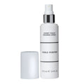 White spray bottle with silver accents labeled Expert Touch Finishing Spray, featuring a sleek modern design, with cap beside it.
