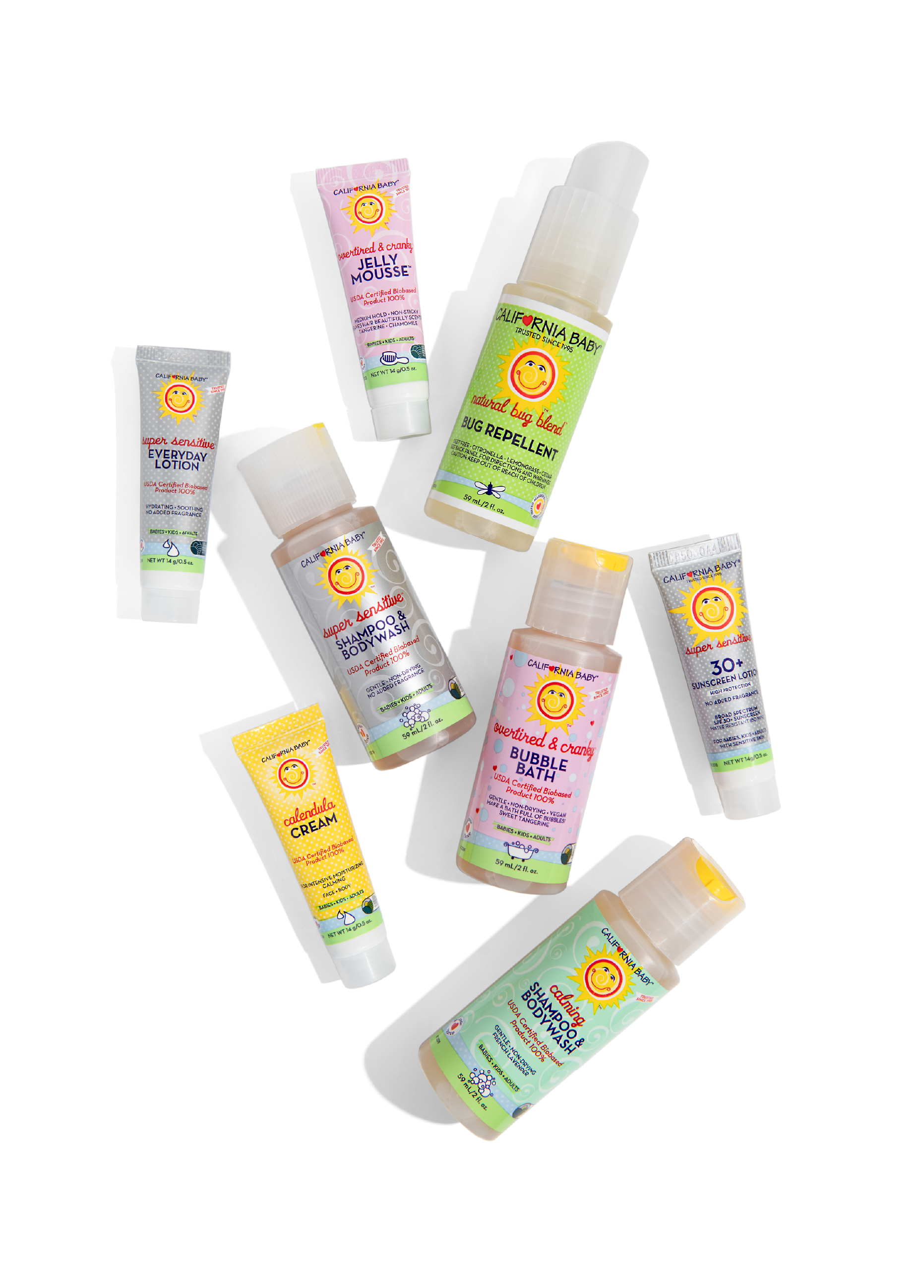 Assorted baby skincare and bath products from the California Baby - Try It Kit, featuring lotions, washes, bug repellent, bubble bath, sunscreen, and cream in colorful packaging designed for gentle, natural care.