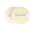 Two soft, round, beige powder puffs with satin bands labeled Merle Norman, designed for smooth makeup application. Merle Norman Cosmetics - Loose Powder Puffs.