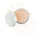 Open jar of loose light beige mineral powder makeup with silver lid and scattered powder around it, showcasing Purely Mineral Makeup.