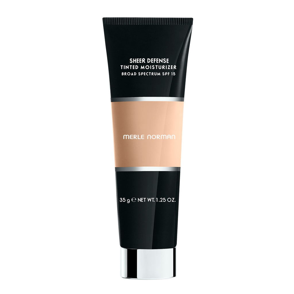Merle Norman Cosmetics - Sheer Defense Tinted Moisturizer SPF 15 in a sleek black and beige tube, offering lightweight, broad spectrum sun protection and a natural look.
