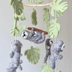 Mobile - Felt Baby - Sloth featuring soft felt sloth figures hanging among green leaves, perfect as a cozy baby accessory from a curated children’s boutique focused on stylish essentials for little ones and moms.