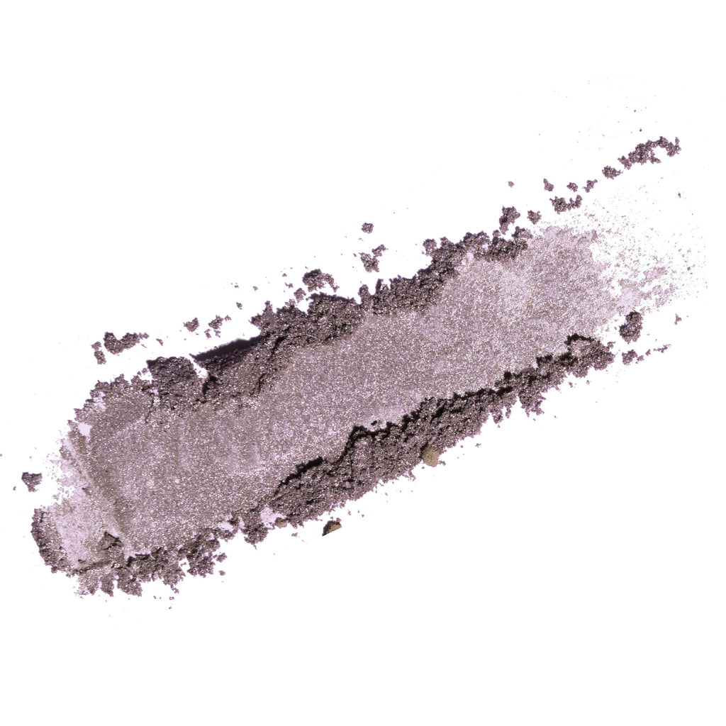 A textured smear of shimmering powder in a dusty lavender-gray shade on a solid white background.