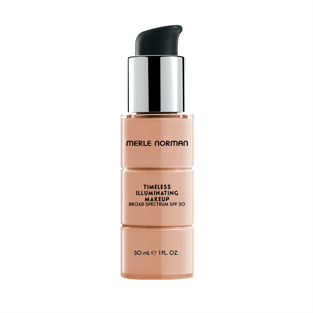 Bottle of Merle Norman Cosmetics - Timeless Illuminating Makeup Broad Spectrum SPF 30 in a light alabaster shade with a black pump and silver collar against a white background.